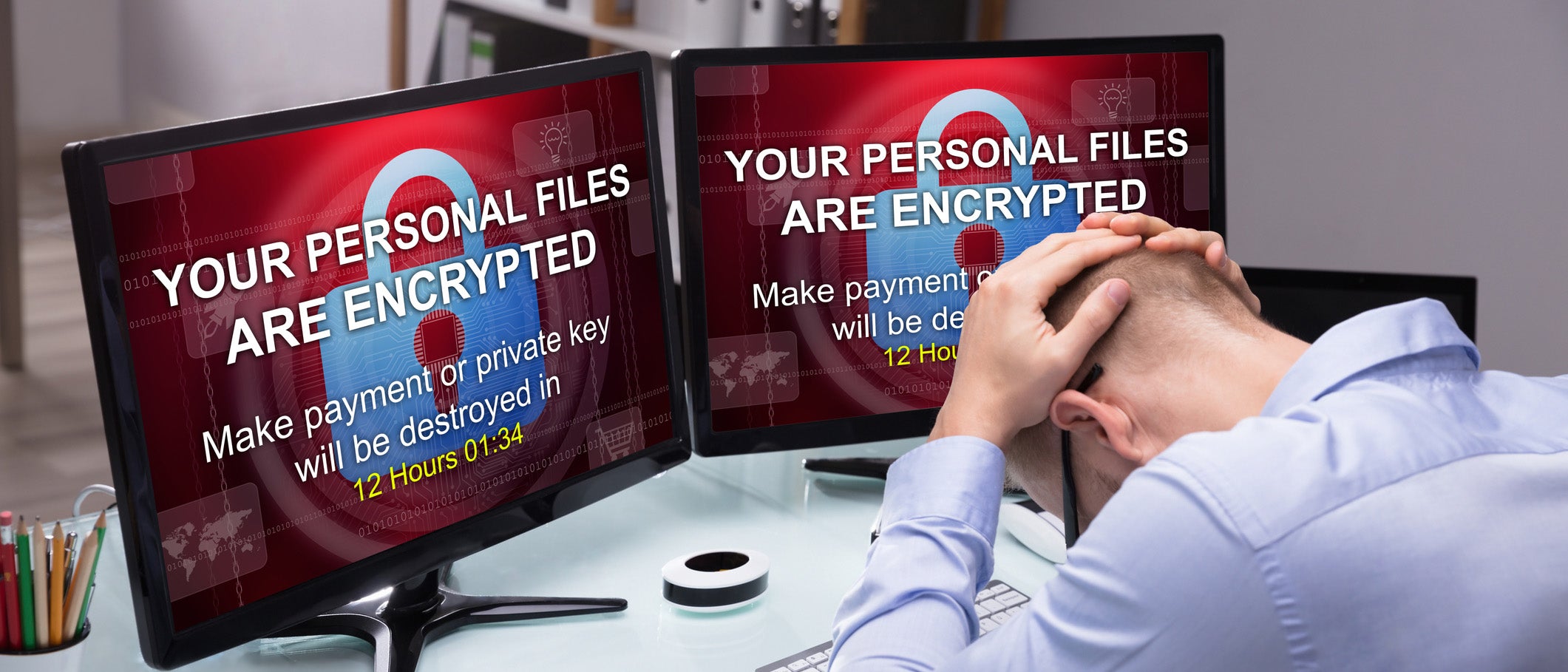 image of two computer screens with security breach and man holding head with hands