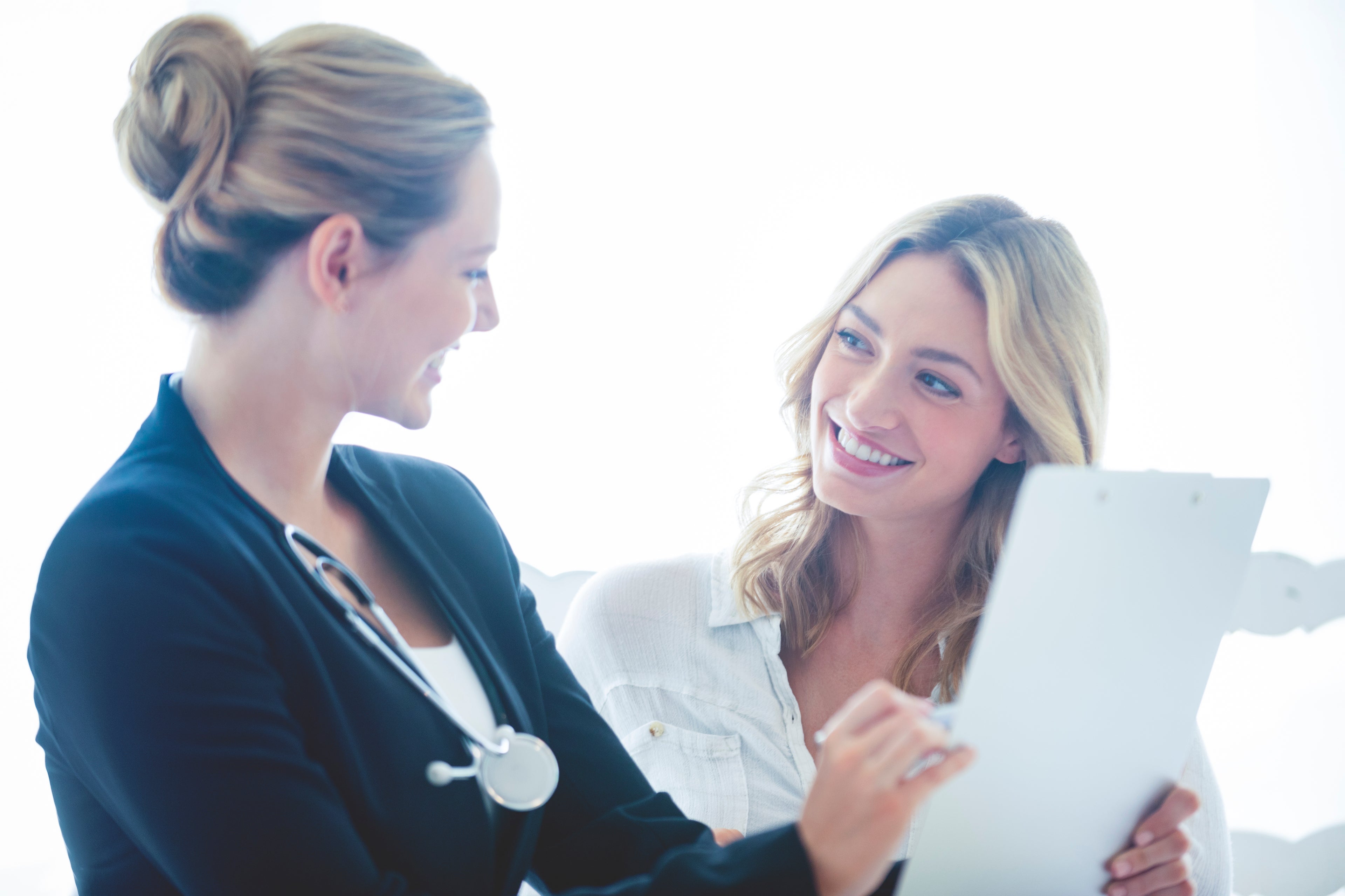 Two professional women looking at a medical record 