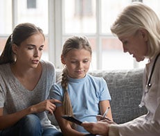 Doctor with teenager and child