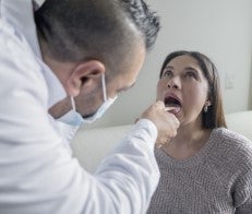 Doctor looking at patient throat