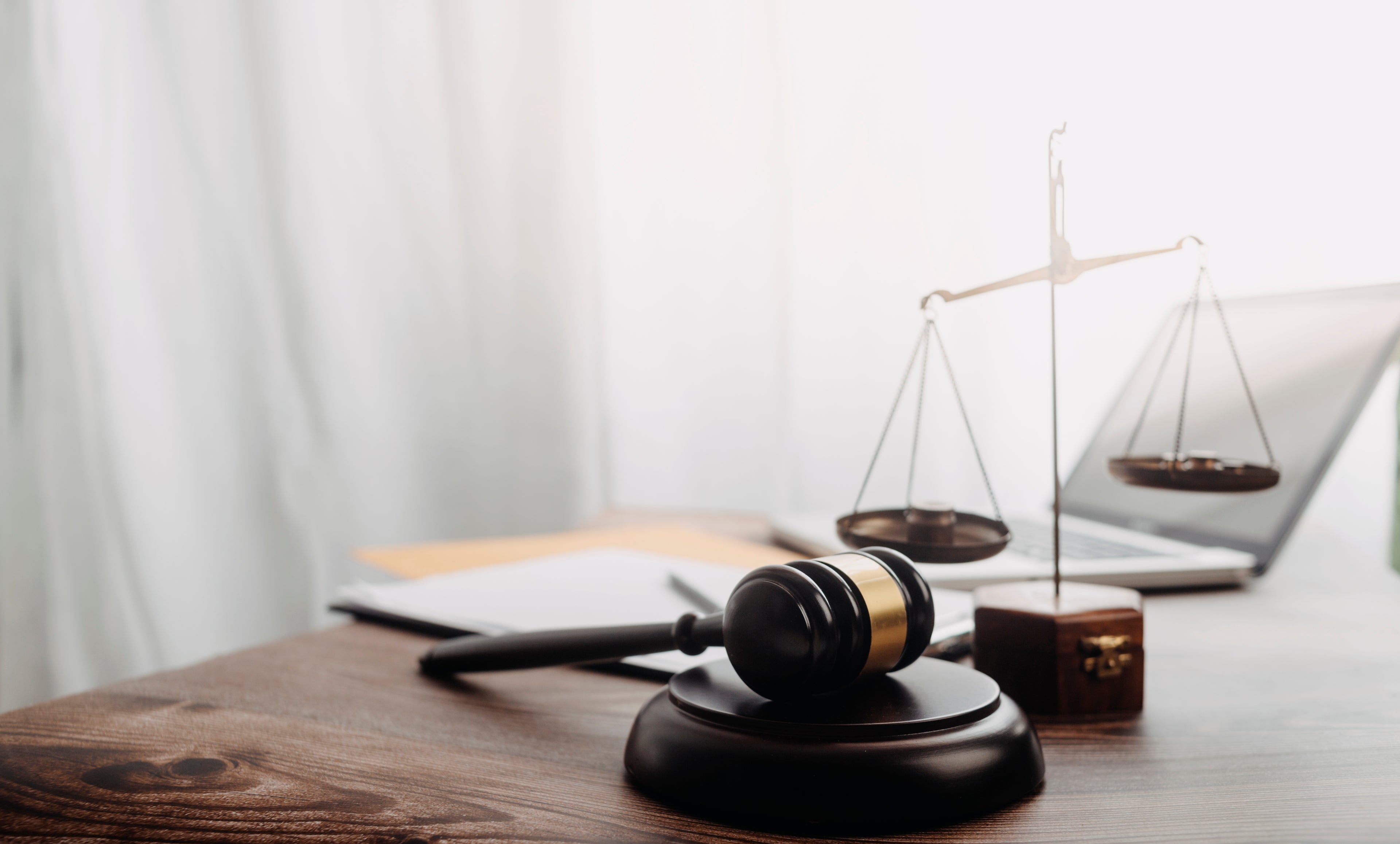 contract papers with brass scale on desk in office.