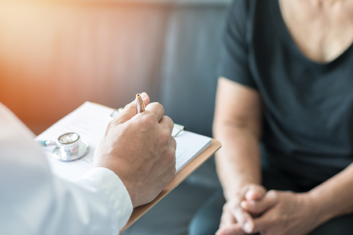 Close up cropped photo of doctor taking notes from patient