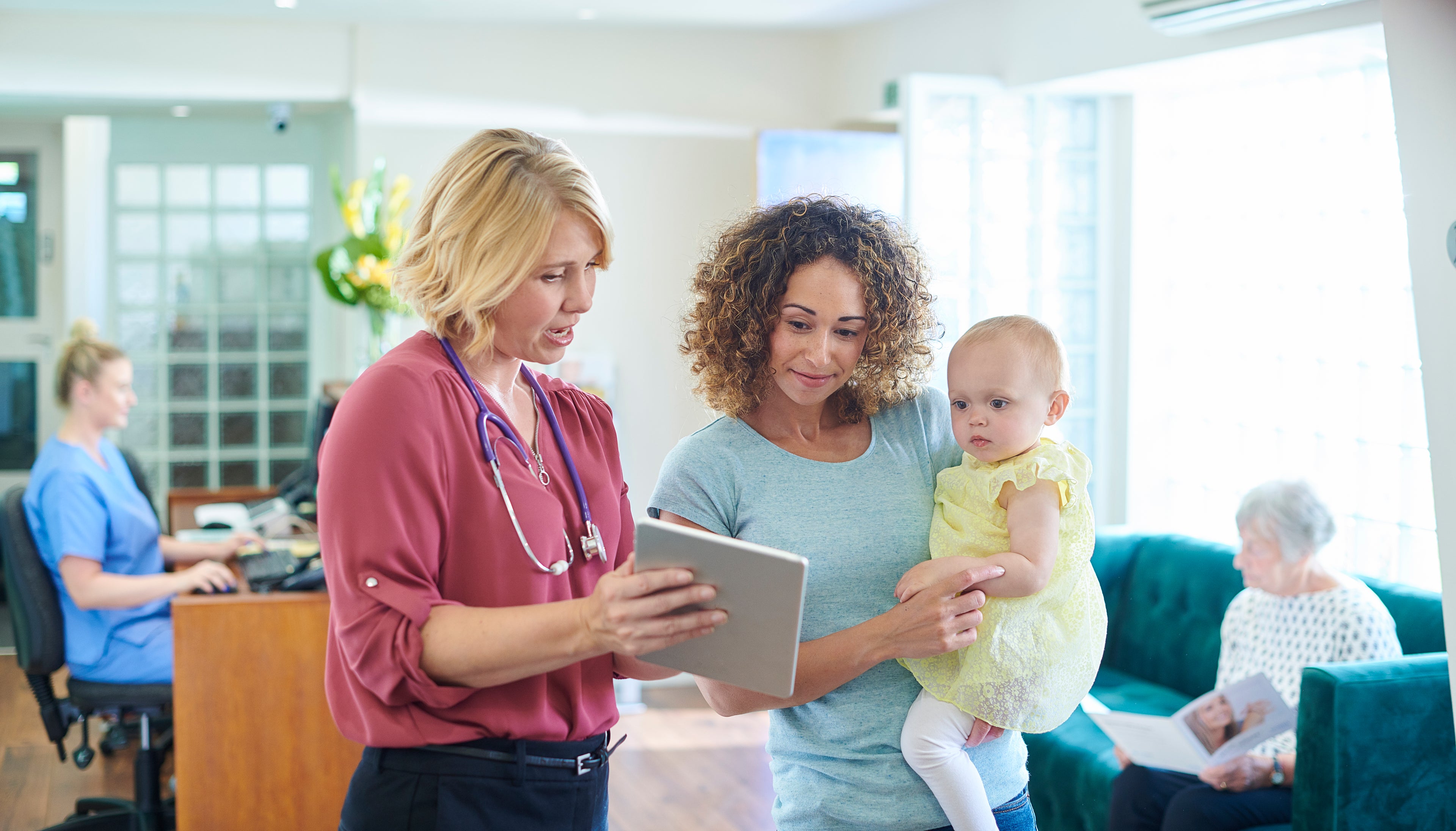 Doctor with a mum and child in waiting room.