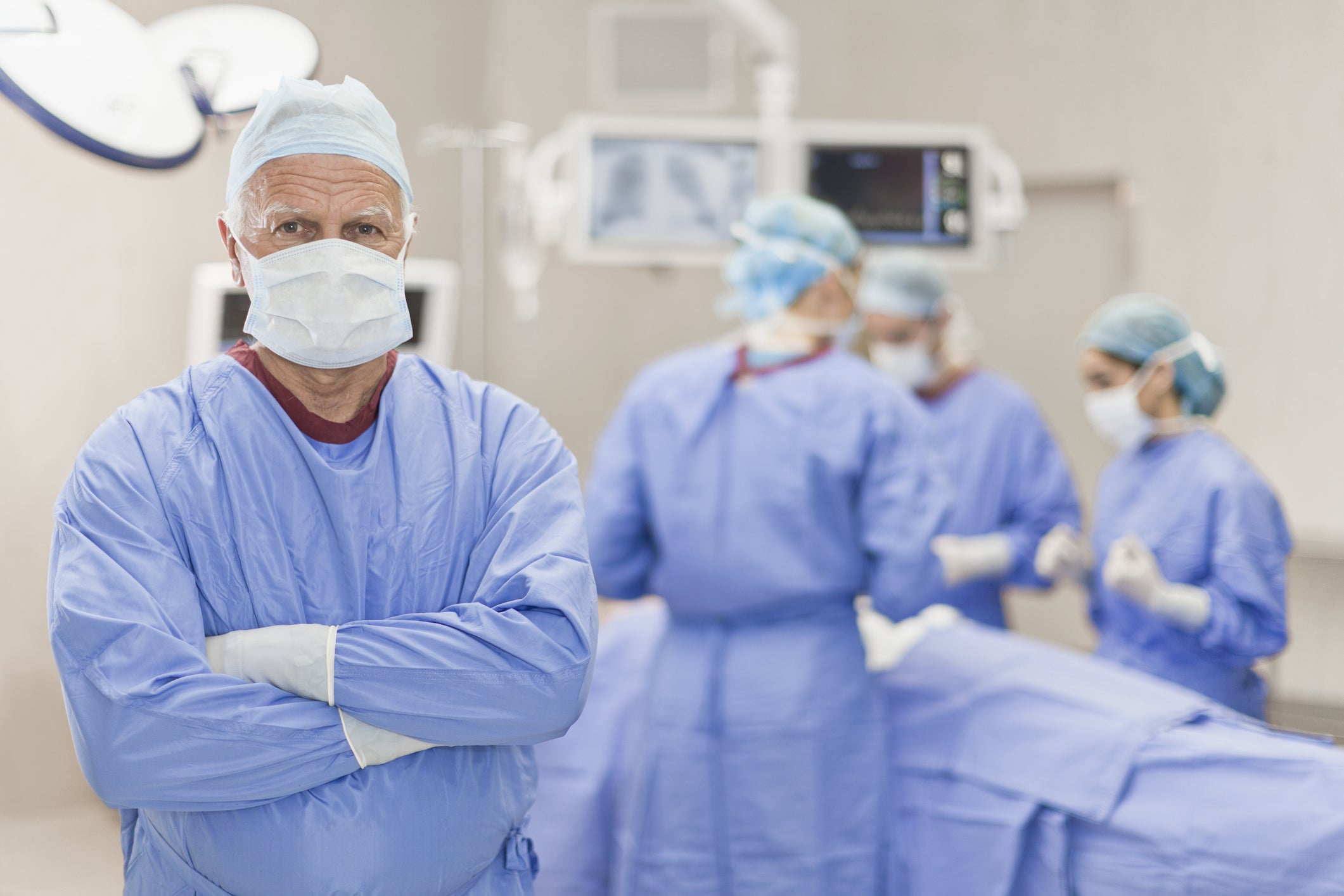 surgeon facing forward surgery in background