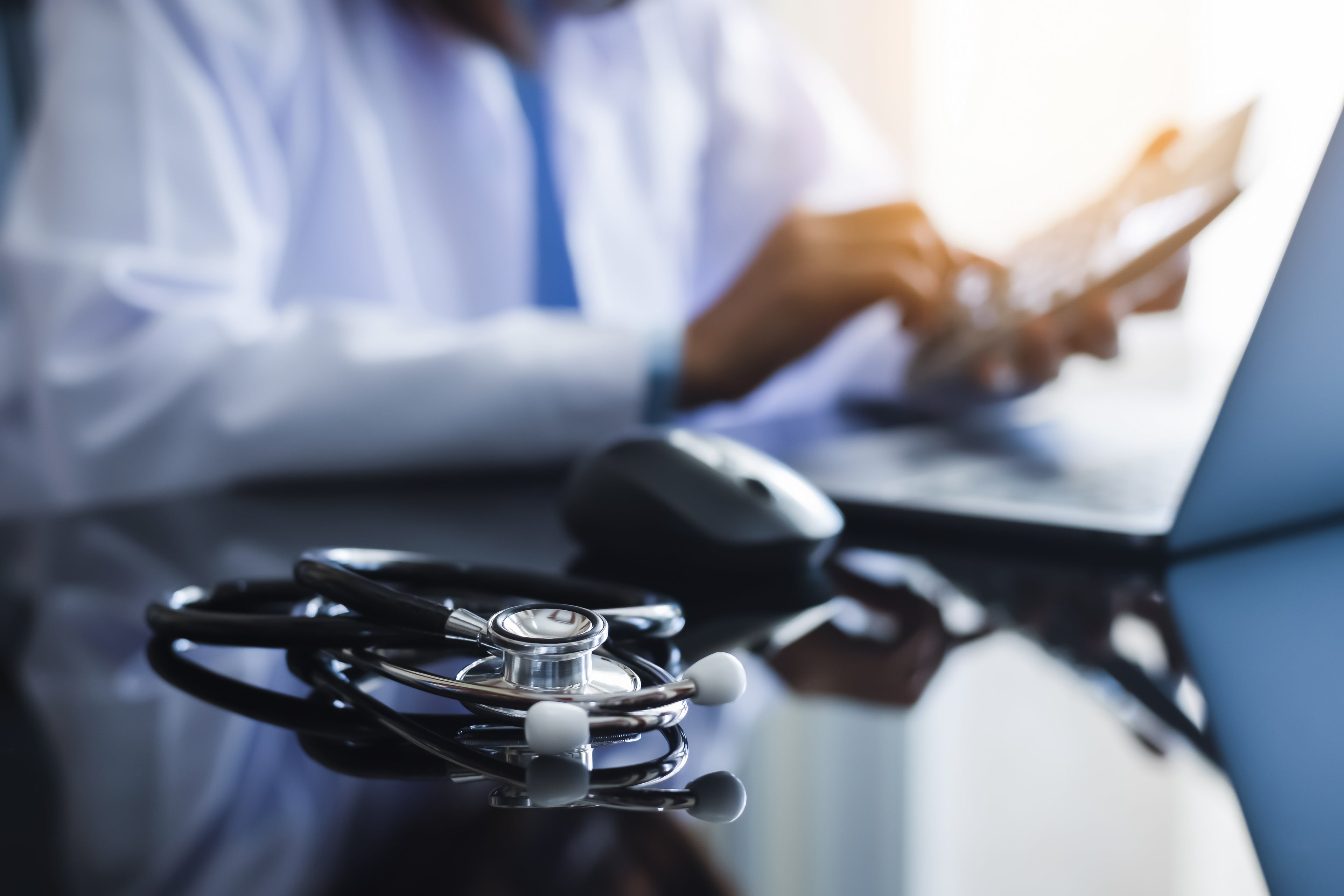 person wearing a headset talking and smiling in front of their computer