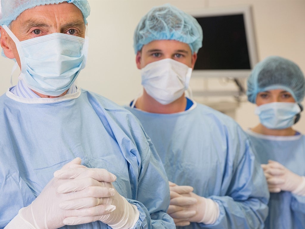 Surgeons in masks ready to operate in operating room