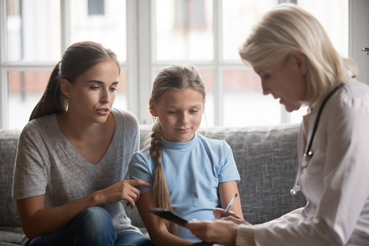 Doctor completing medical certificate with parent and child