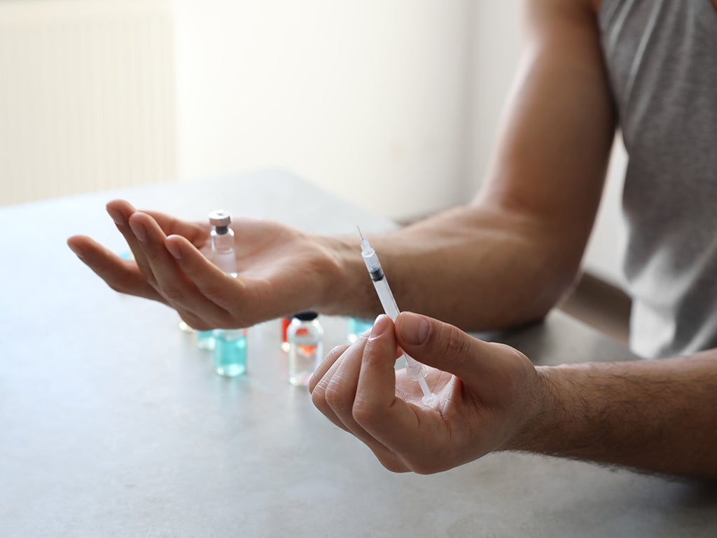 Doctor holding a medical vial along with a small 1ml syringe