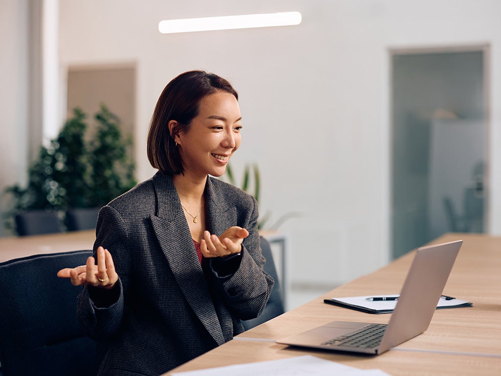 Woman in suit talking to laptop